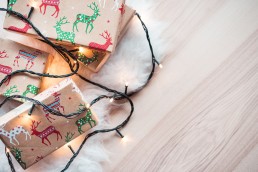 Kerstwensen kerstcadeaus verpakt kerstlichtjes parket vloer