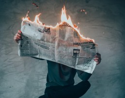 Crisiscommunicatie Man leest brandende krant